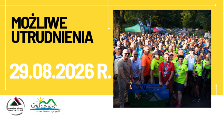 Na zdjęciu widoczna jest liczna grupa uczestników Maratonu Pieszego „Sudecka Żyleta” zgromadzona przed startem wydarzenia. Uczestnicy ubrani są w stroje sportowe i turystyczne. W tle znajdują się drzewa, namioty organizatorów oraz flagi wydarzenia.